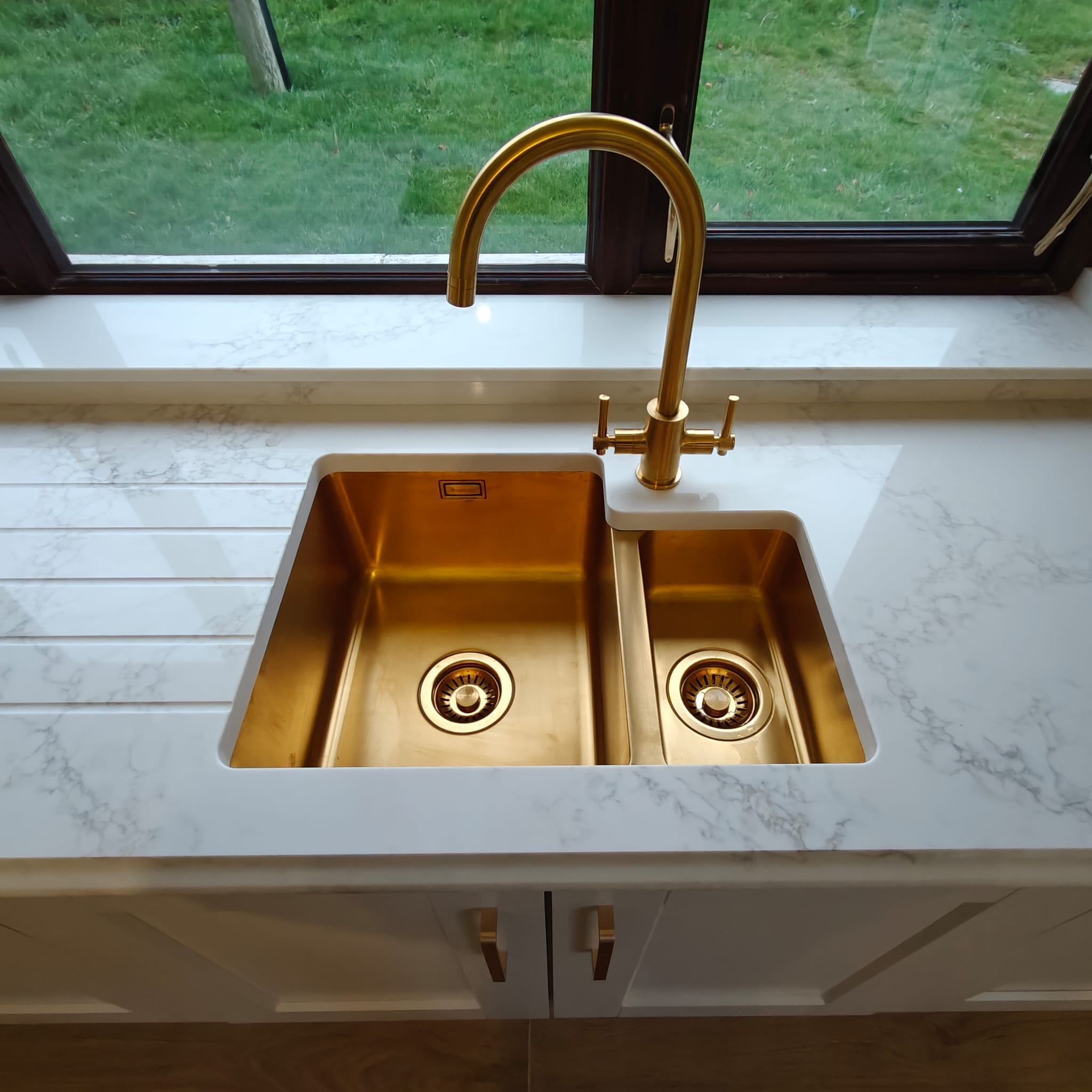 Gold kitchen sink set into a stone worktop