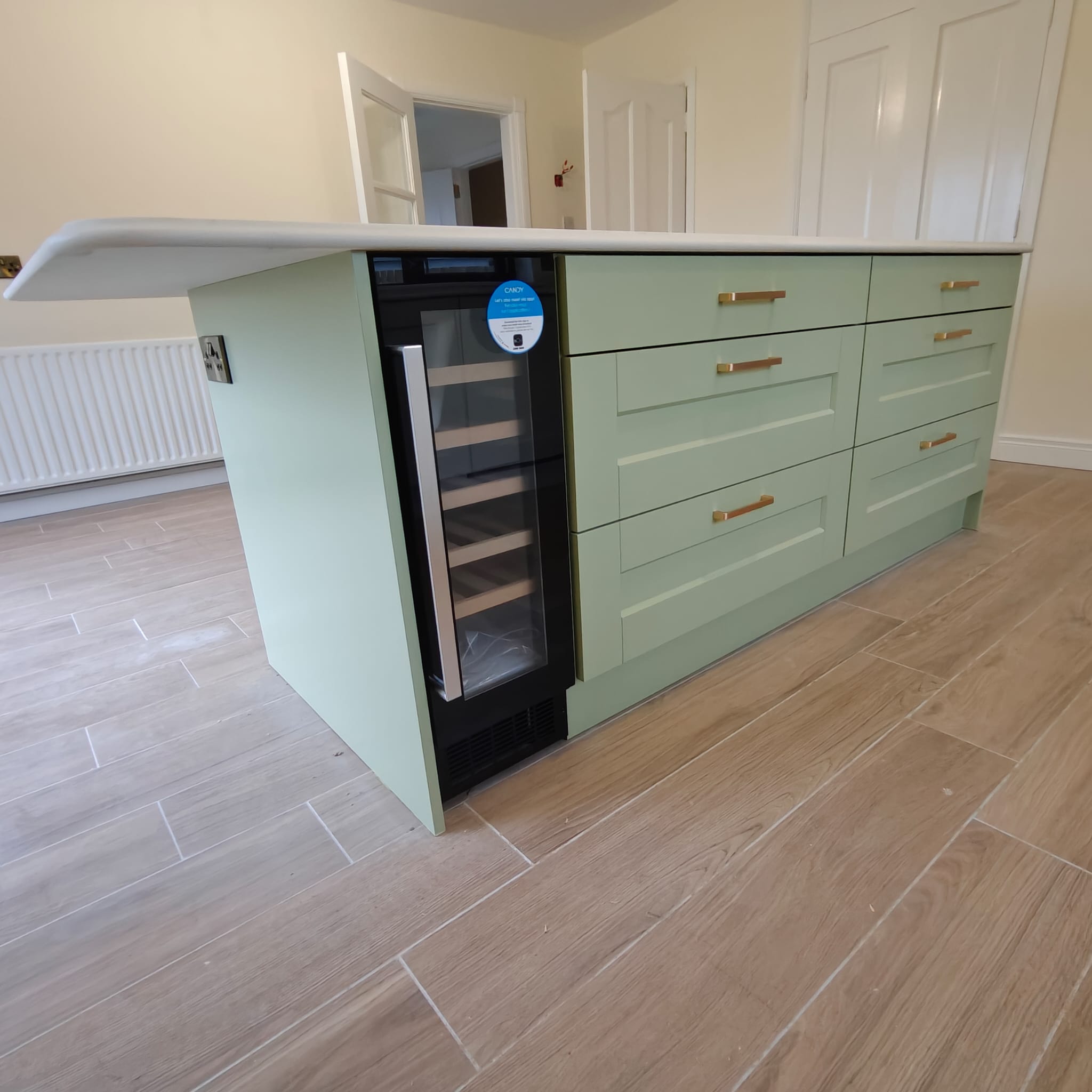 Green kitchen island with integrated wine cooler